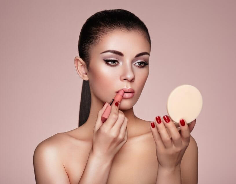 beautiful-woman-paints-lips-with-lipstick-PMB6YWP