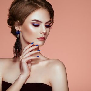 Portrait Beautiful Woman with Jewelry. Model Girl with Blue Manicure on Nails. Elegant Hairstyle. Blue Make-up Arrows. Beauty and Accessories